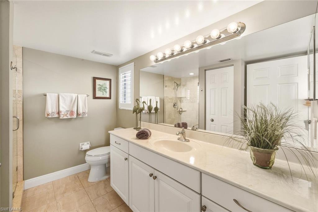7772 Emerald Circle, Unit 101 Naples, FL 34109 - Photo 18 of 37 a bathroom with a potted plant on the counter and a sink