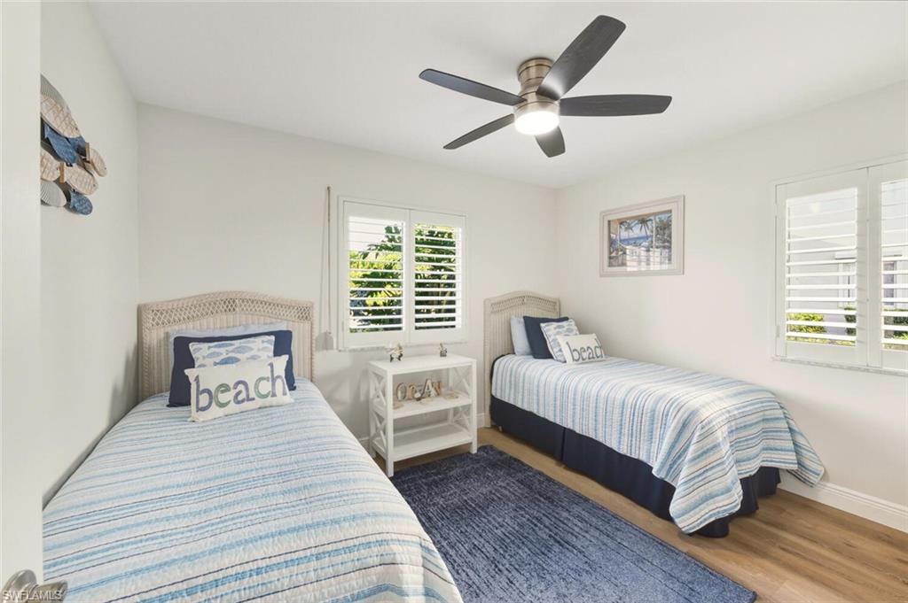 7772 Emerald Circle, Unit 101 Naples, FL 34109 - Photo 21 of 37 a bedroom with a large bed and a large window