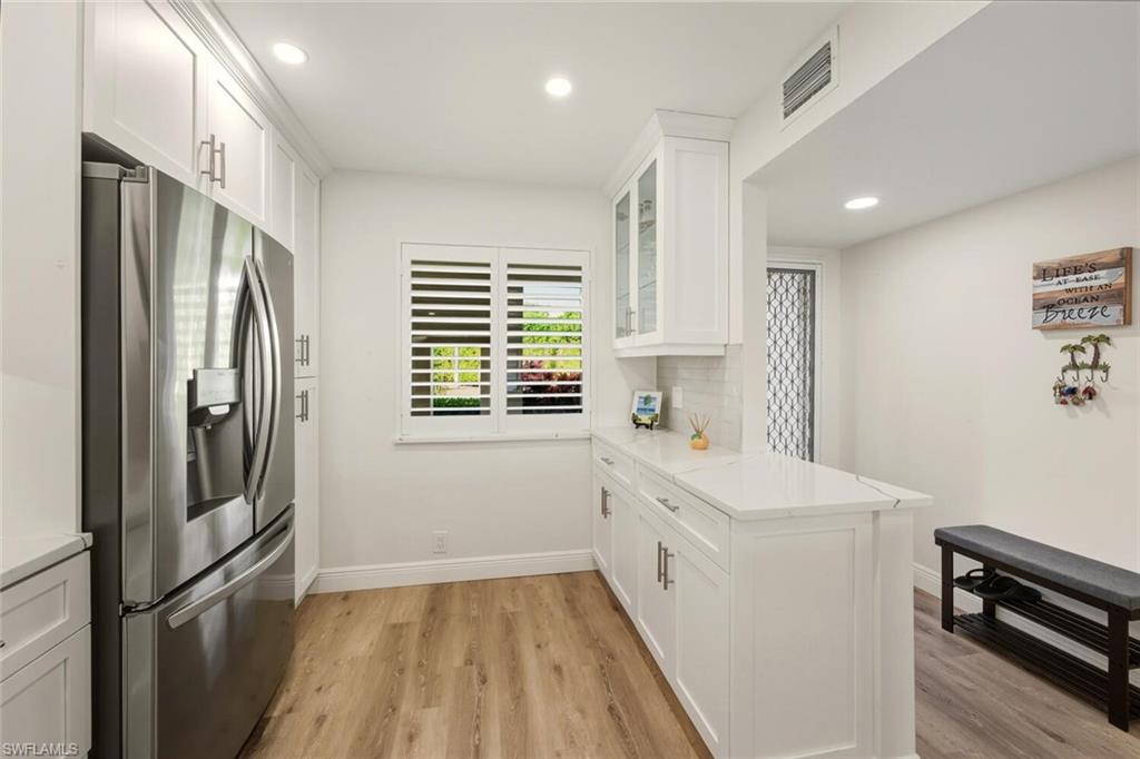 7772 Emerald Circle, Unit 101 Naples, FL 34109 - Photo 8 of 37 a kitchen with a refrigerator a stove and cabinets