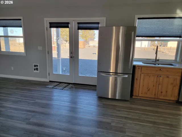 a view of a kitchen with wooden floor and electronic appliances