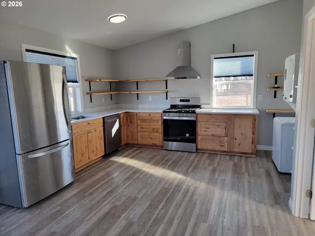 a kitchen with stainless steel appliances granite countertop a refrigerator and a stove