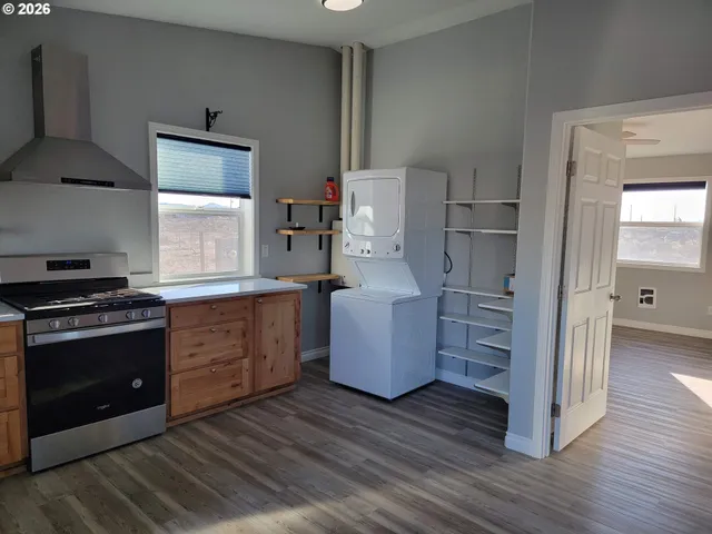 a kitchen with granite countertop a refrigerator and a stove top oven