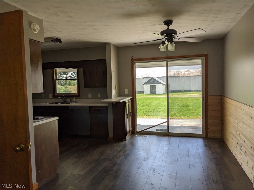 13096 Smith Road Wellington, OH 44090 - Photo 9 of 24 Kitchen and dining area featuring dark wood-finish flooring, a ceiling fan with integrated lighting, and a sliding glass door leading to the exterior
