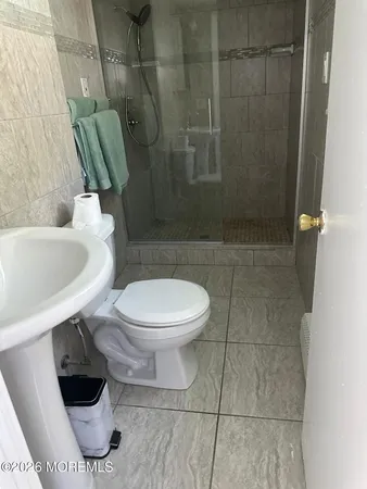 a white toilet sitting next to a bath tub and a shower