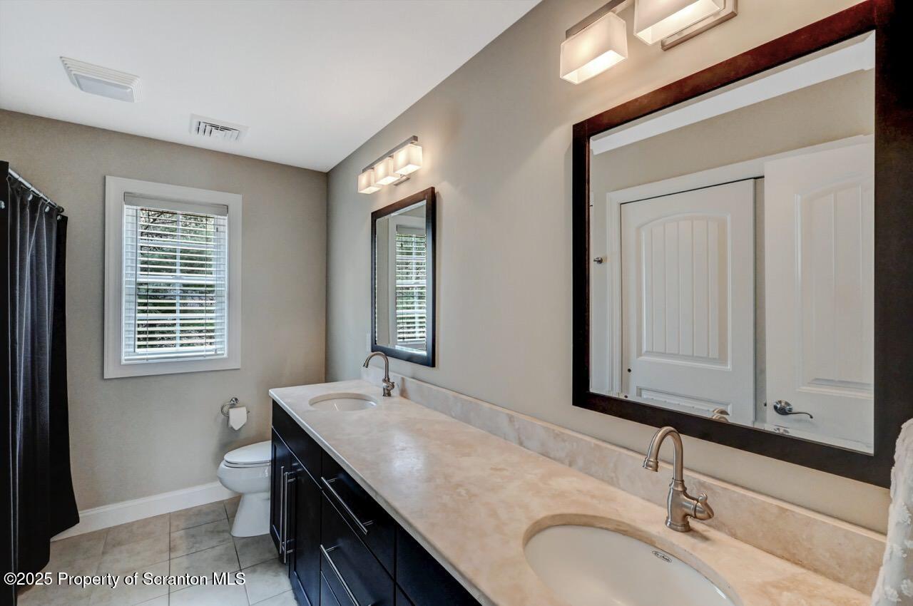 120 Highland Road Moscow, PA 18444 - Photo 53 of 84 a bathroom with a granite countertop sink a toilet and a mirror