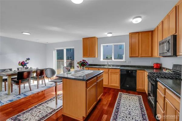 a kitchen with stainless steel appliances granite countertop sink stove top oven and cabinets