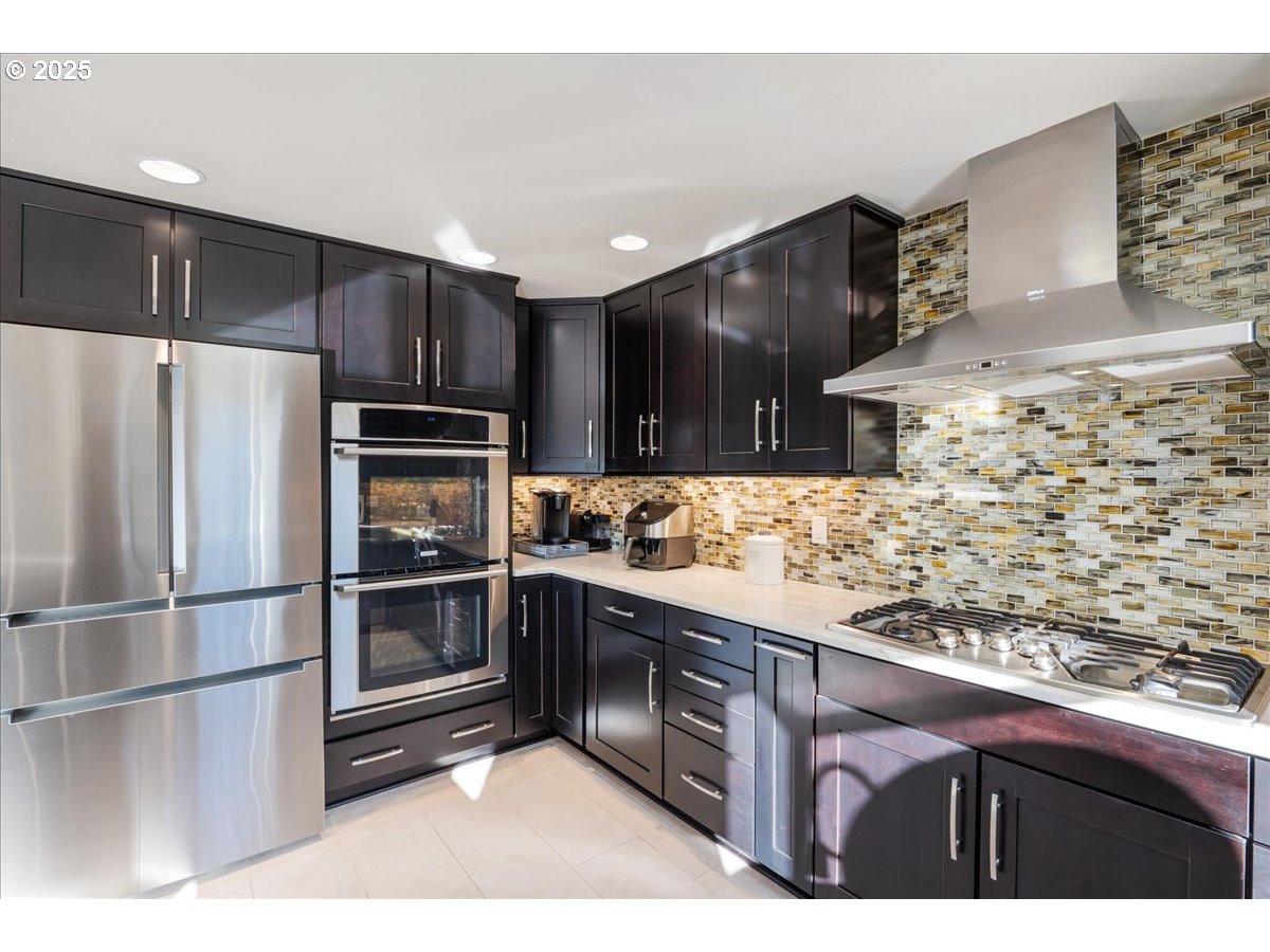 15735 Southwest 88th Avenue Portland, OR 97224 - Photo 13 of 38 a kitchen with stainless steel appliances kitchen island granite countertop a refrigerator and a stove top oven