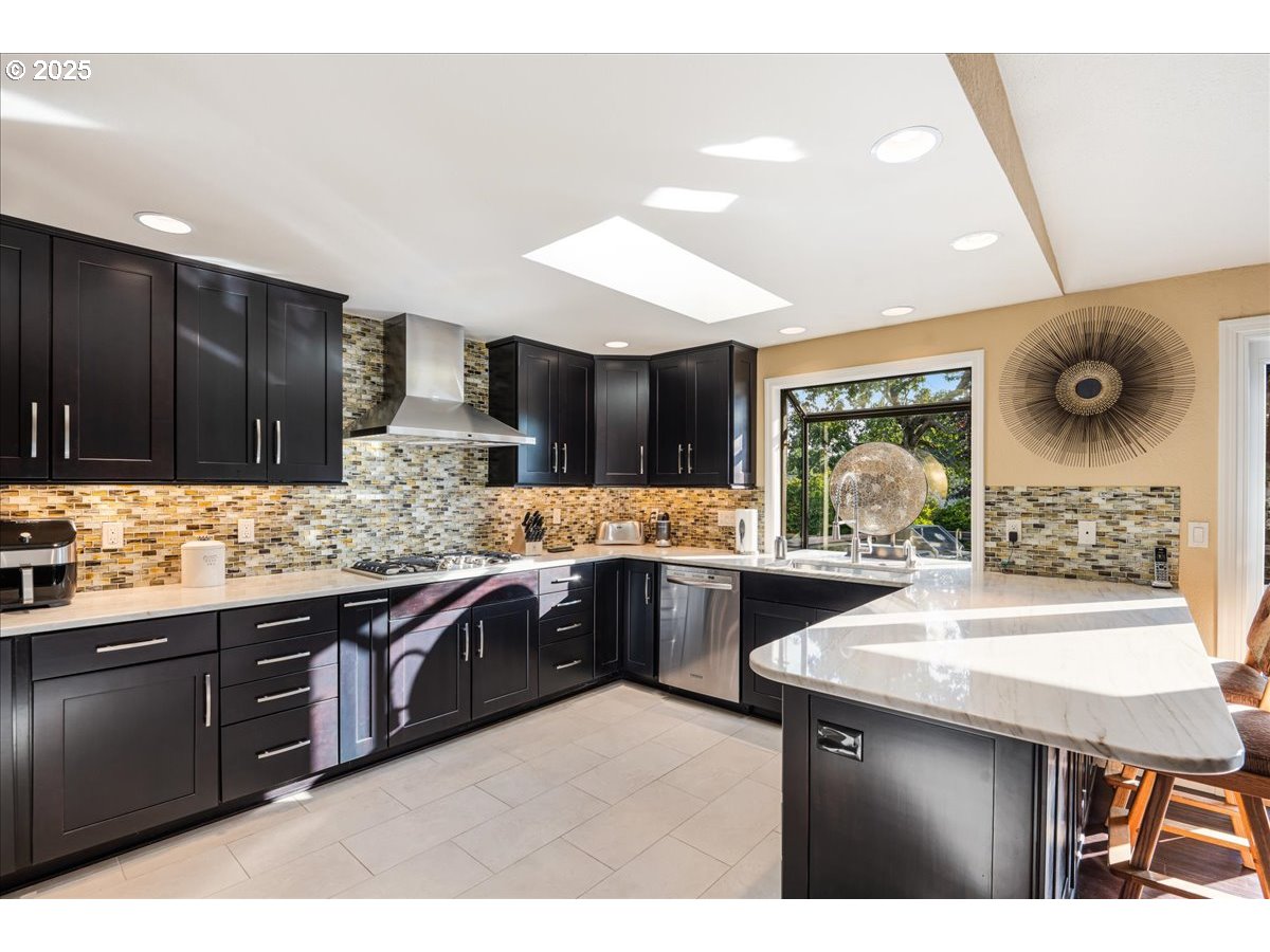 15735 Southwest 88th Avenue Portland, OR 97224 - Photo 14 of 38 a kitchen with lots of counter top space sink and stainless steel appliances