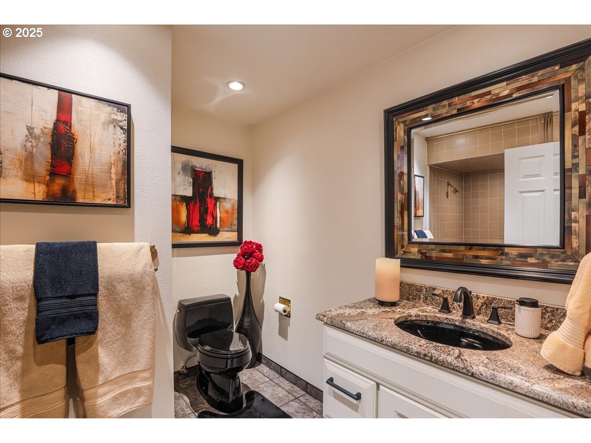 15735 Southwest 88th Avenue Portland, OR 97224 - Photo 16 of 38 a bathroom with a granite countertop sink and a mirror