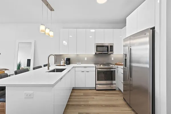 a kitchen with stainless steel appliances granite countertop a sink a refrigerator and a stove