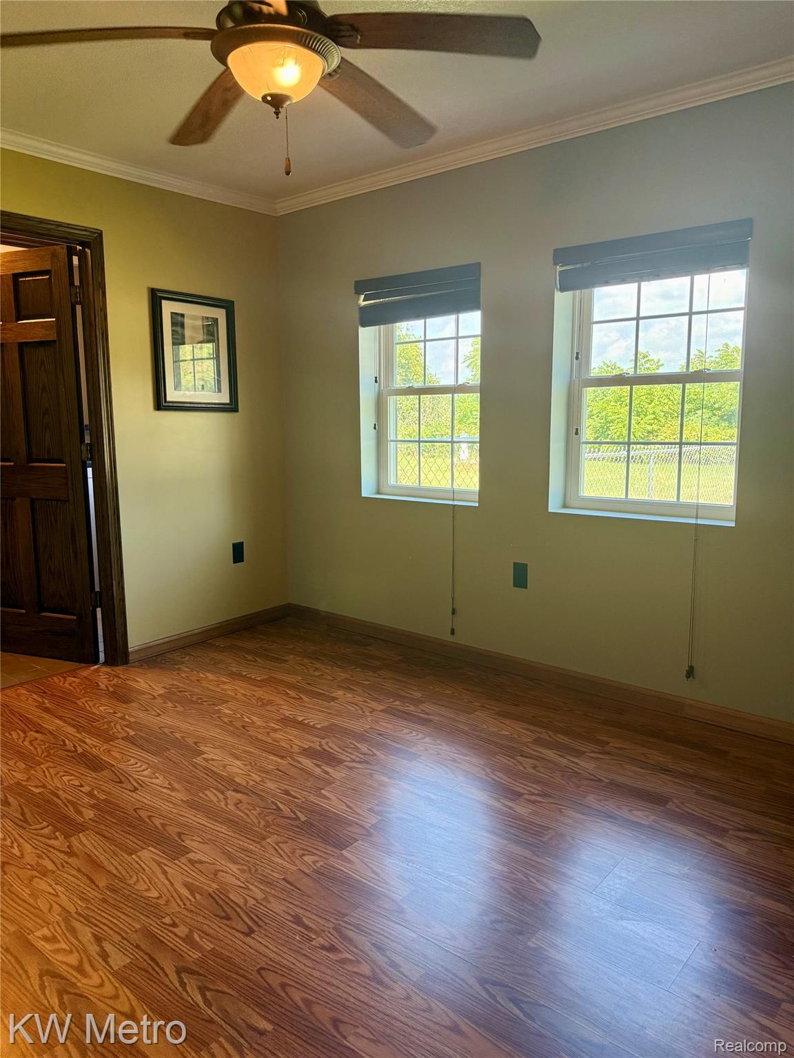 5982 South Mission Road Mount Pleasant, MI 48858 - Photo 7 of 32 Spare room with ornamental molding, wood finished floors, and a ceiling fan