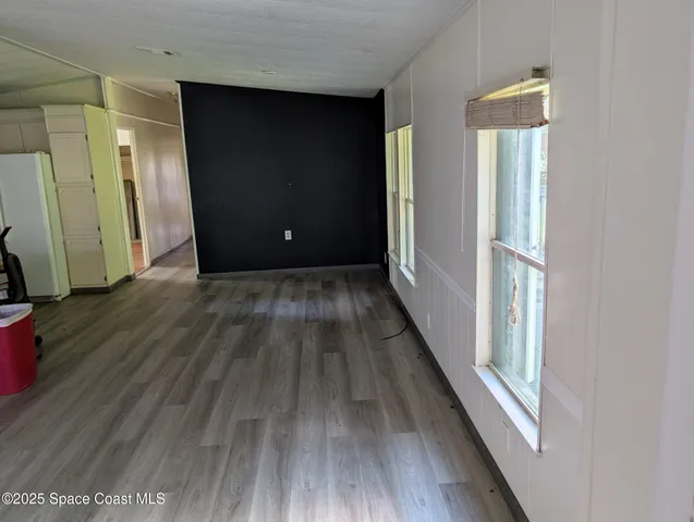 a view of a hallway with wooden floor and stairs