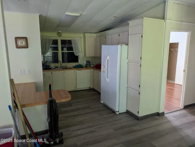 a kitchen with stainless steel appliances wooden floors and wooden cabinets