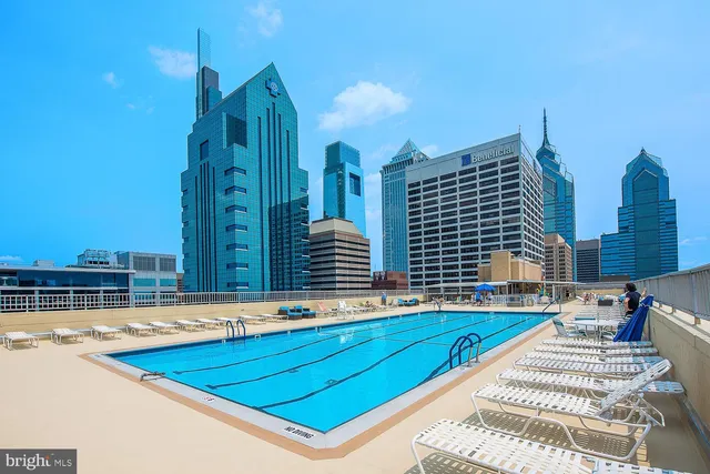 a view of swimming pool with outdoor seating and city view
