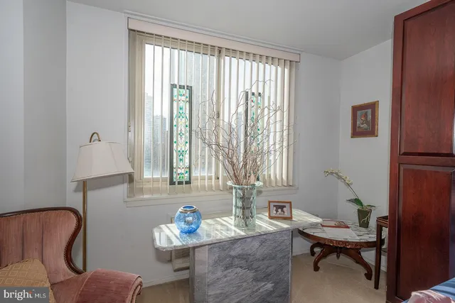 a view of a workspace with furniture and a window