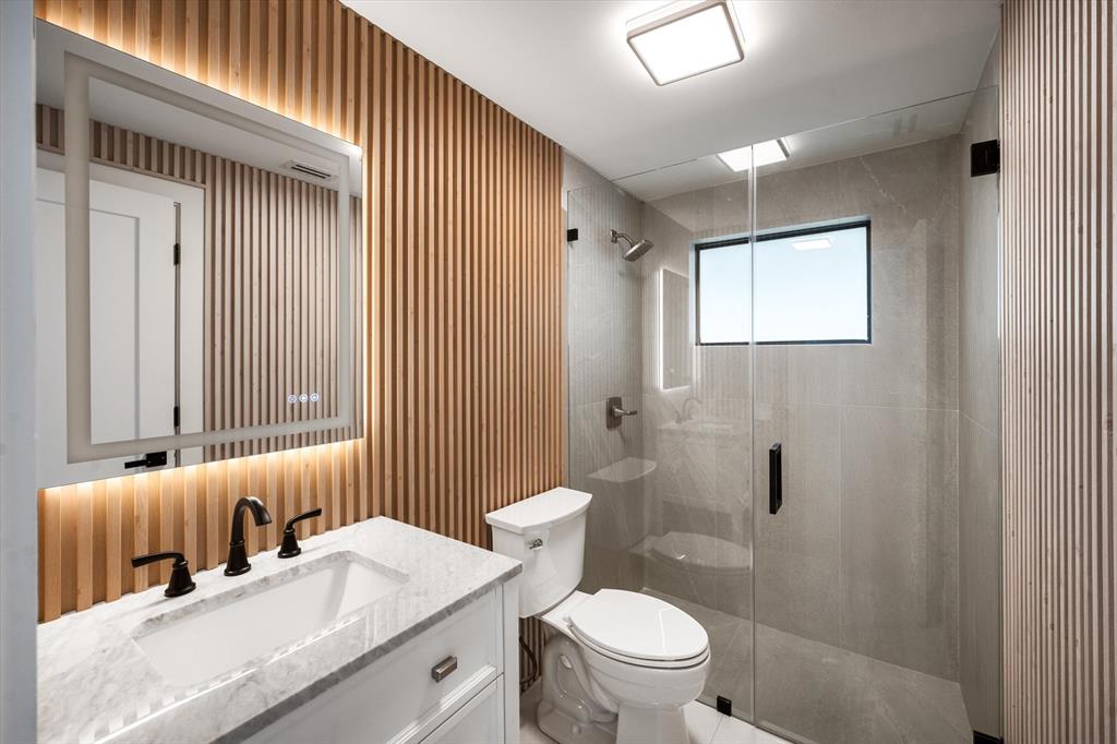 10201 Southwest 64th Street Miami, FL 33173 - Photo 42 of 50 a bathroom with a granite countertop sink a toilet and shower