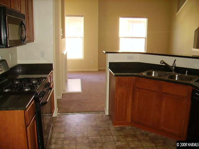 9050 Double R Boulevard, Unit 521 Reno, NV 89521 - Photo 3 of 6 a kitchen with granite countertop a sink a stove and cabinets