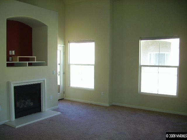 9050 Double R Boulevard, Unit 521 Reno, NV 89521 - Photo 4 of 6 a living room with a fireplace and a window