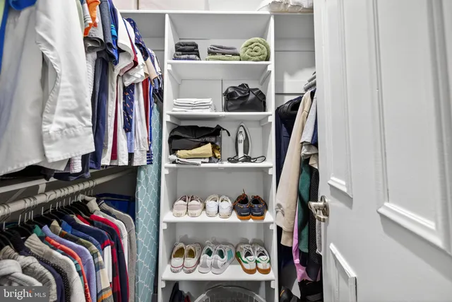 a view of walk in closet with clothes and shoes
