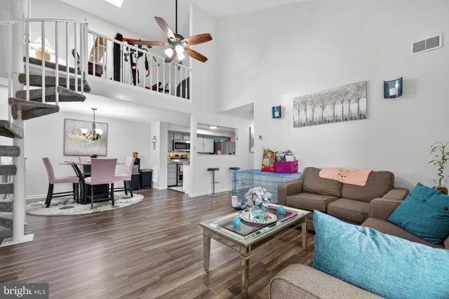 a living room with furniture a ceiling fan and a wooden floor
