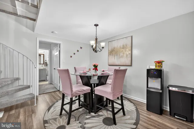 a dining room with furniture a chandelier and wooden floor