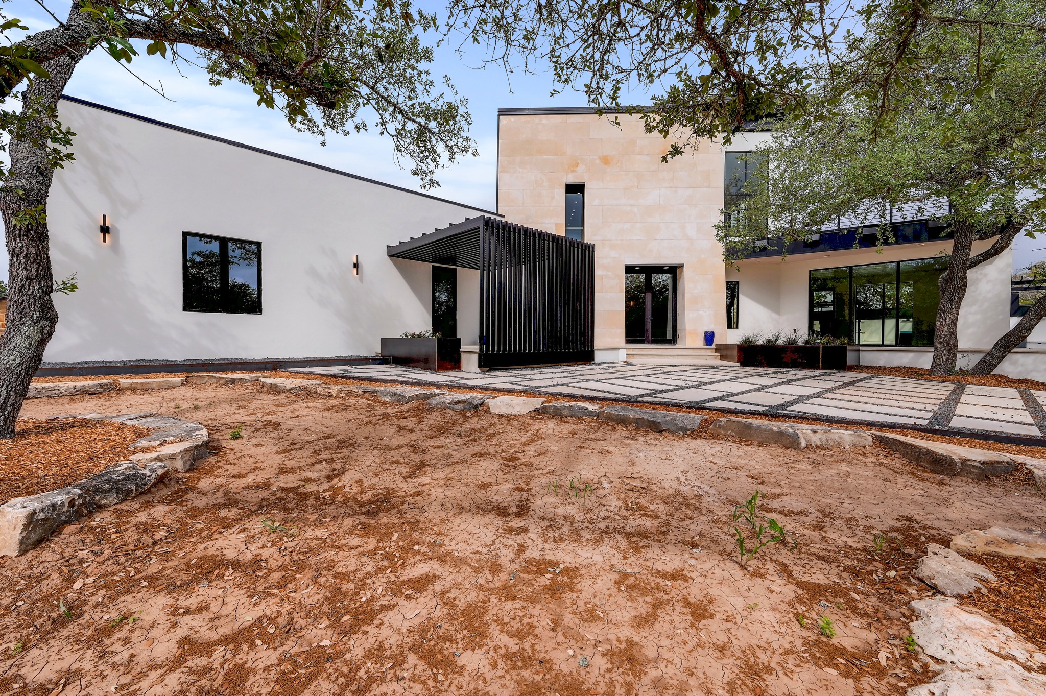 700 Rancho Grande Drive Wimberley, TX 78676 - Photo 2 of 39 Modern exterior featuring a prominent stone facade and white stucco