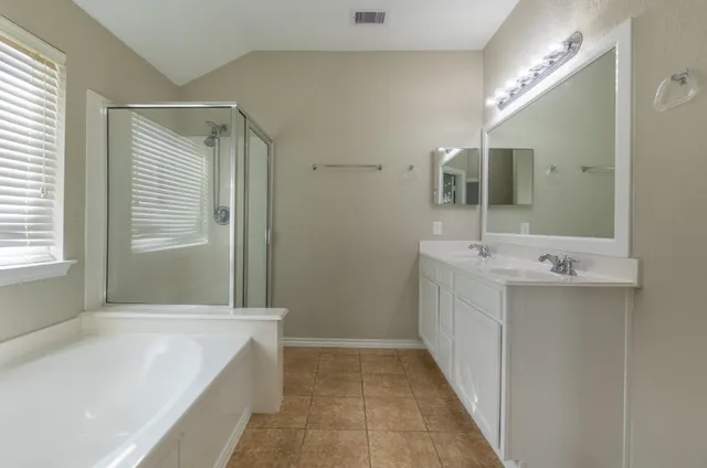 a bathroom with a tub sink and mirror