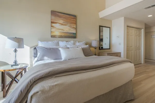 a bedroom with a bed and a painting on the wall