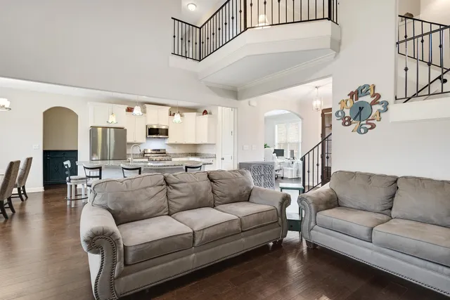 a living room with furniture white walls and a chandelier
