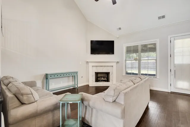 a living room with furniture a flat screen tv and a fireplace