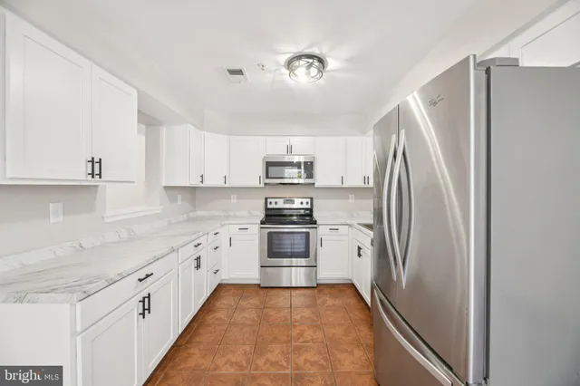 a kitchen with stainless steel appliances granite countertop a refrigerator and a sink