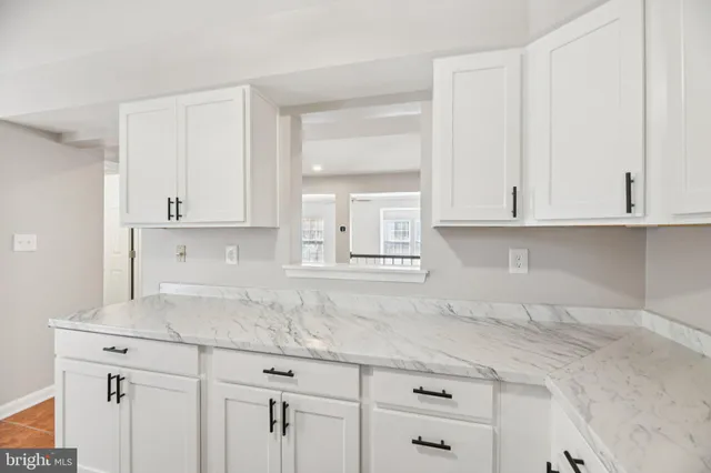 a kitchen with granite countertop white cabinets and a sink
