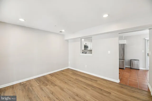 a view of empty room with wooden floor
