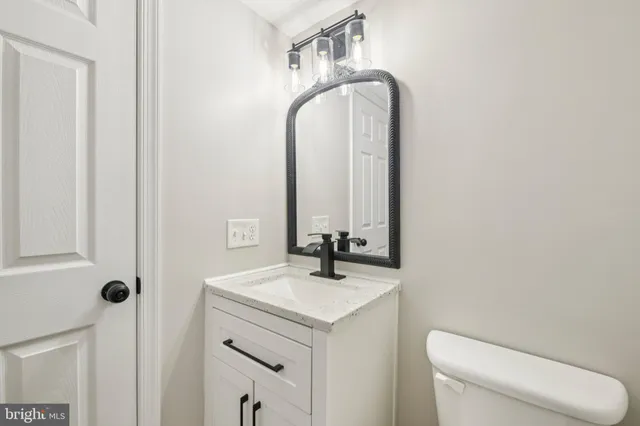 a bathroom with a toilet sink and mirror