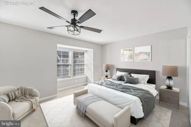 a bedroom with a large bed and two window