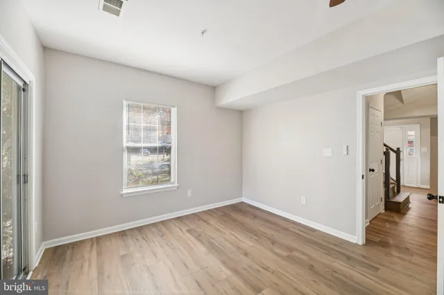 an empty room with wooden floor and a window