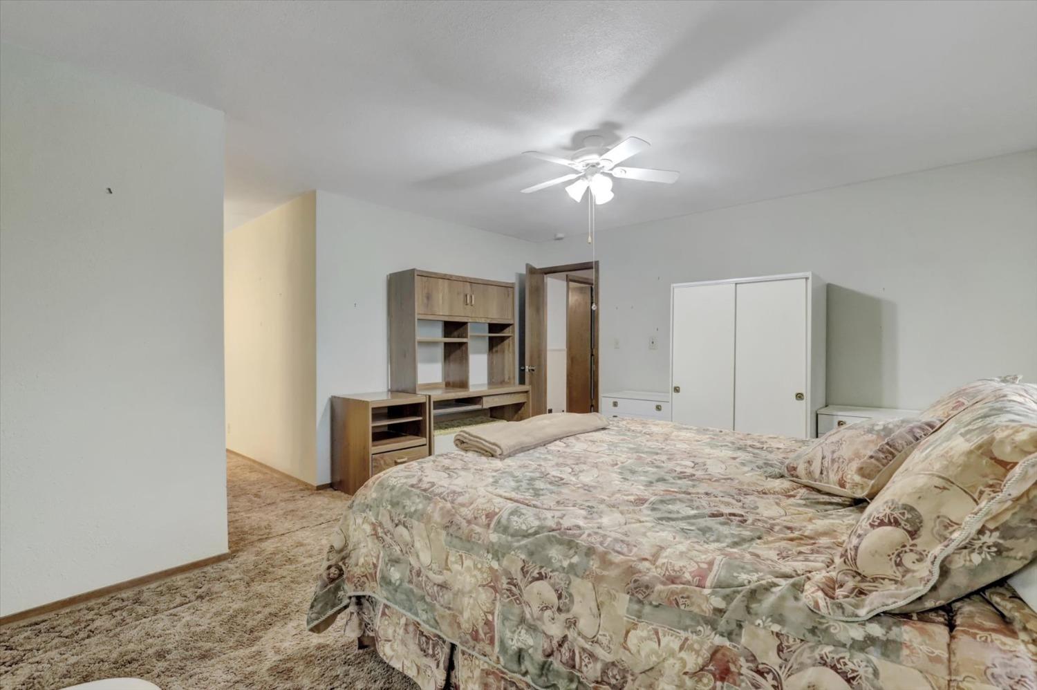 13032 Thistle Loop Penn Valley, CA 95946 - Photo 12 of 30 a bedroom with a large bed and a chandelier