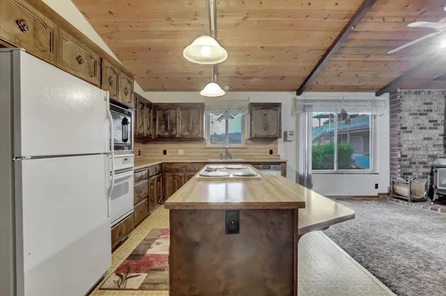 a kitchen with a refrigerator a sink and dishwasher with a dining table