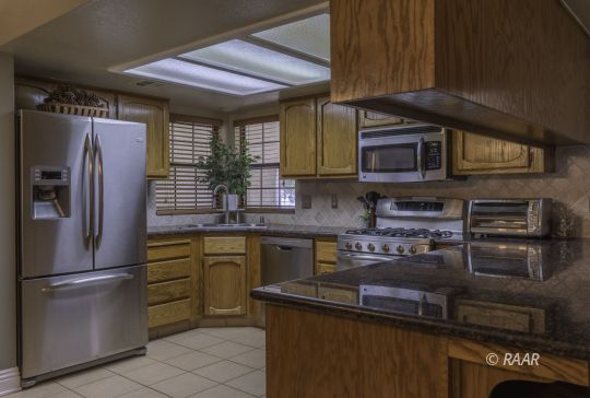 815 James Street Ridgecrest, CA 93555 - Photo 5 of 27 a kitchen with stainless steel appliances granite countertop a refrigerator and a stove top oven