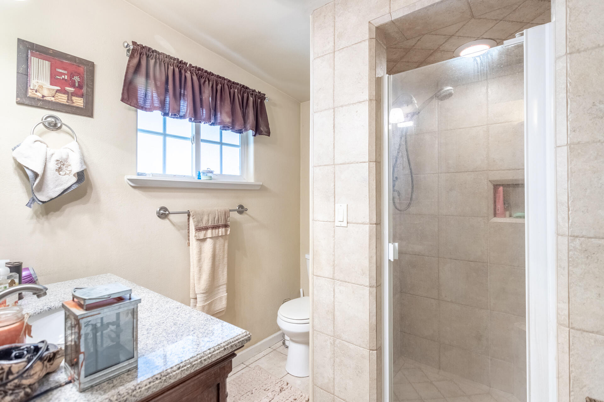 406 South Jackson Street Red Bluff, CA 96080 - Photo 13 of 26 a bathroom with a granite countertop sink a toilet and a shower
