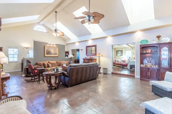 a living room with furniture kitchen view and a wooden floor