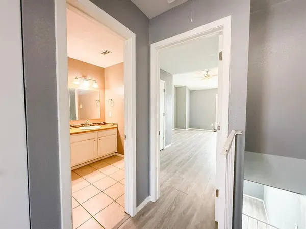 a view of a hallway with a dining table & chairs in a kitchen