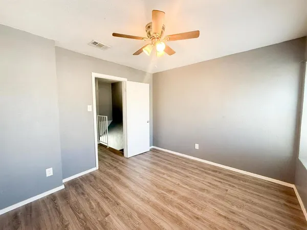 a view of a backyard with large trees and wooden fence