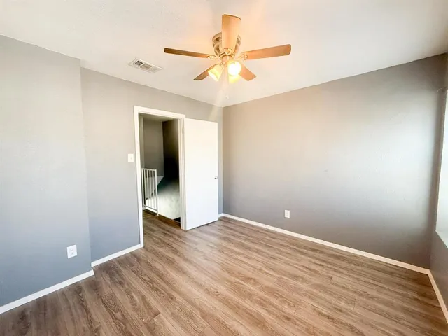 a view of a backyard with large trees and wooden fence
