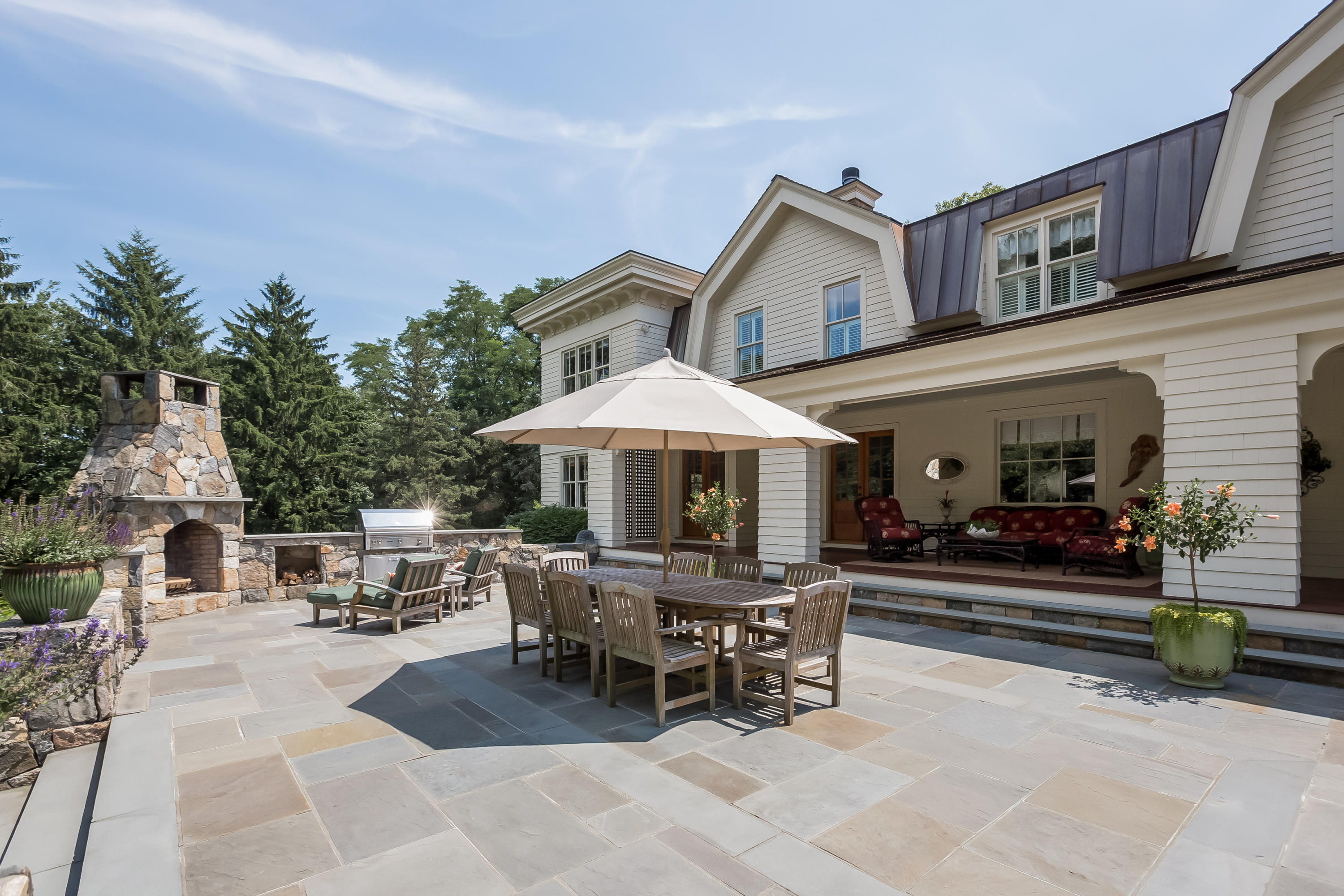 62 Stanton Road Darien, CT 06820 - Photo 40 of 52 a patio with a table and chairs under an umbrella