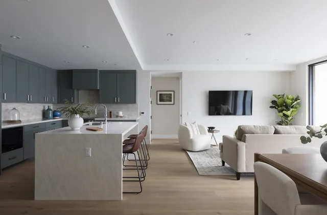 a living room with furniture a flat screen tv and kitchen view