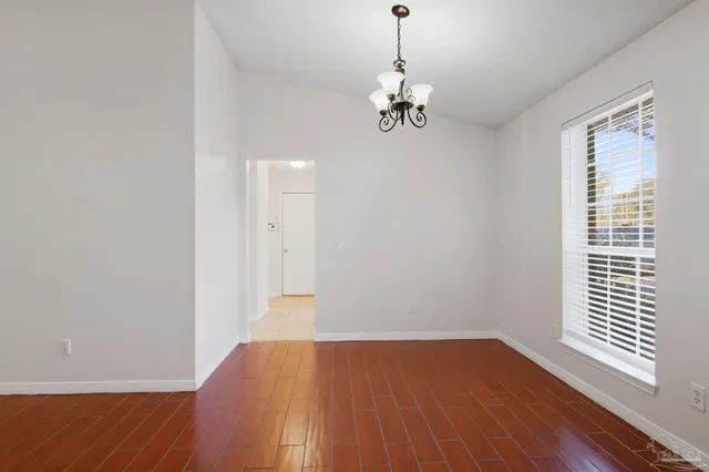 a view of empty room with wooden floor and window