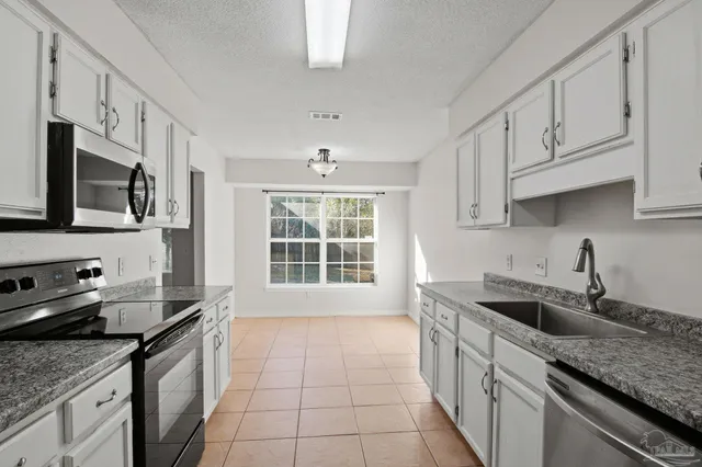 a kitchen with stainless steel appliances granite countertop a sink stove and cabinets