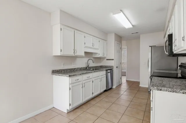 a kitchen with stainless steel appliances granite countertop a sink and a stove