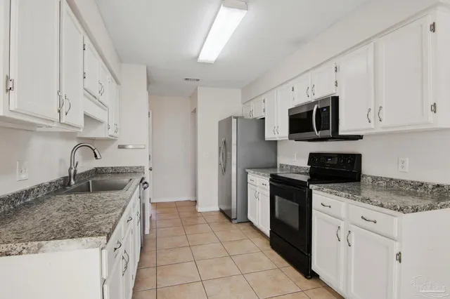 a kitchen with stainless steel appliances granite countertop a sink stove microwave and refrigerator